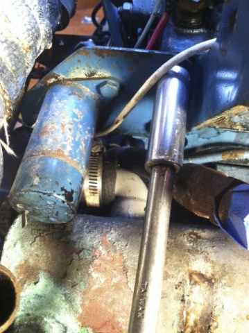 Zoom in Removing the stop solenoid to reach the hose clamp hidden behind.